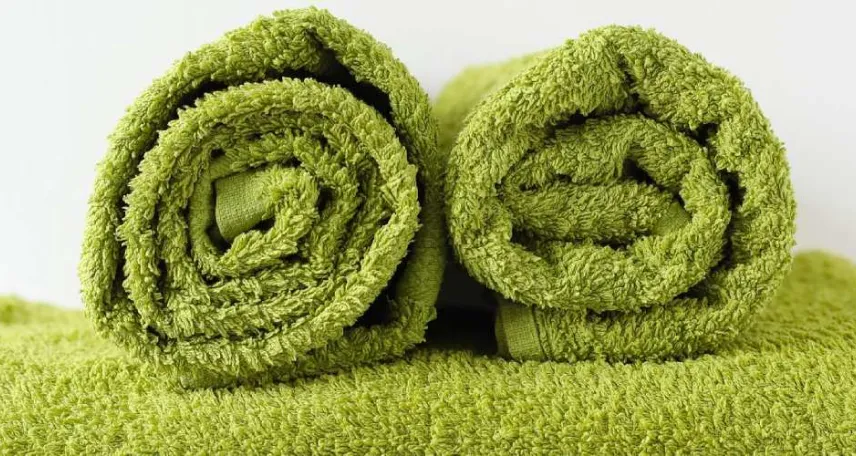 due asciugamani verdi posizionati su un altro asciugamano