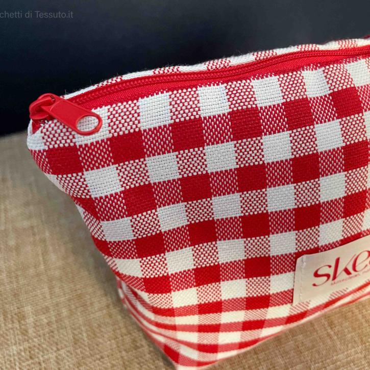 Dettaglio laterale pochette in tessuto quadrettato rosso e bianco con manico in stoffa