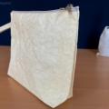 Dettaglio Pochette in stoffa effetto carta con zip lampo e maniglia
